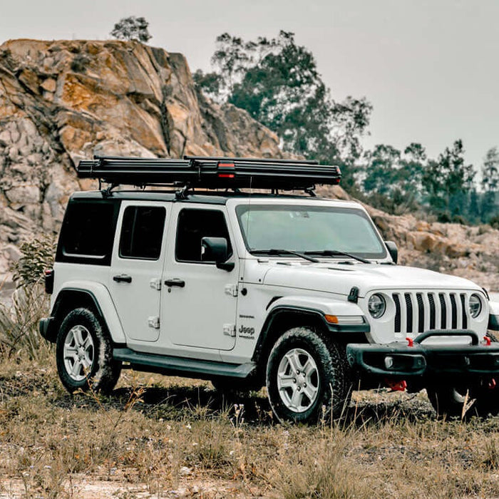 Jeep Wrangler bianca con tenda da tetto Wild Land chiusa su una pista in una cava