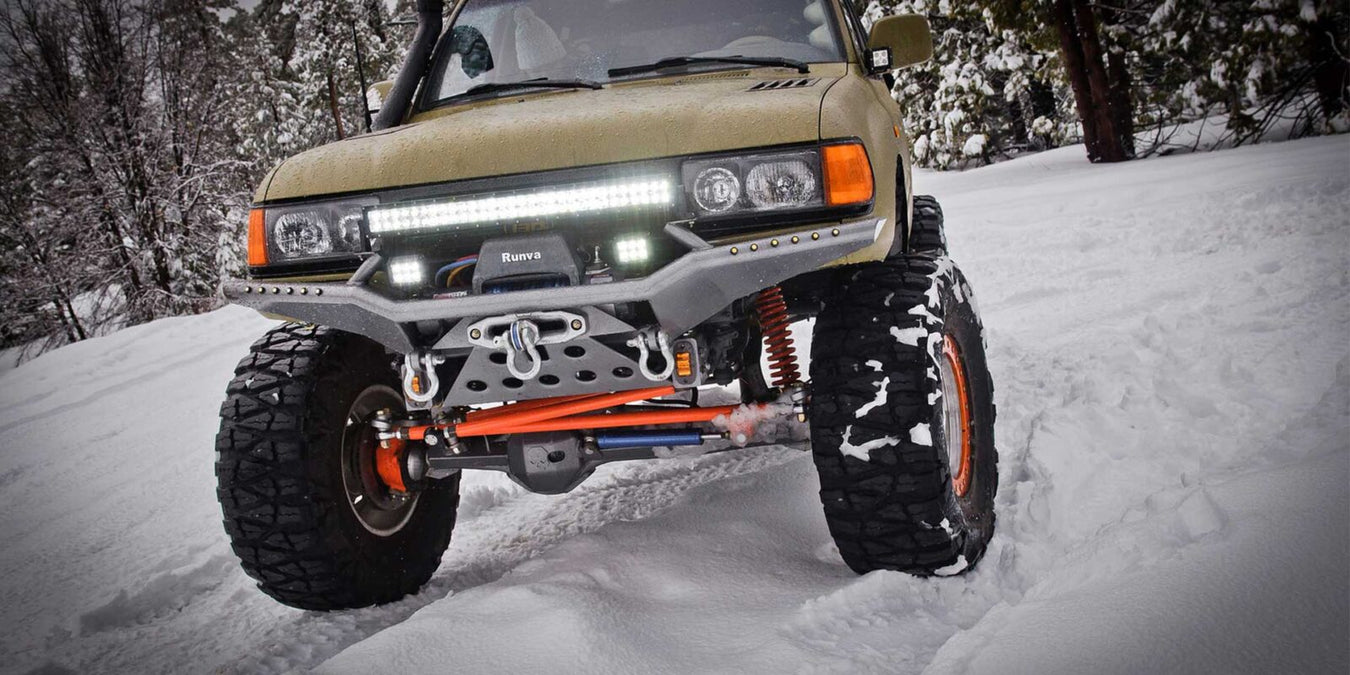 Pick-up con barra LED e fari da lavoro accesi in fuoristrada sulla neve