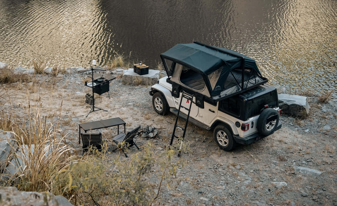 Jeep con tenda da tetto Wild Land aperta vicino al fiume