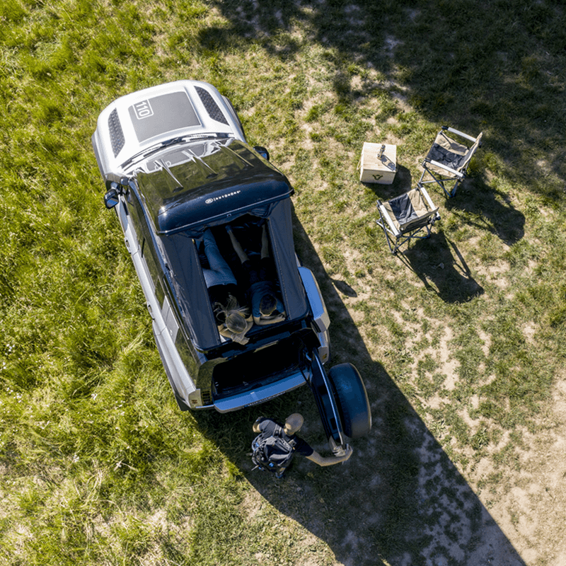 Campo con tenda da tetto Autohome, sedie e tavolo, vista aerea