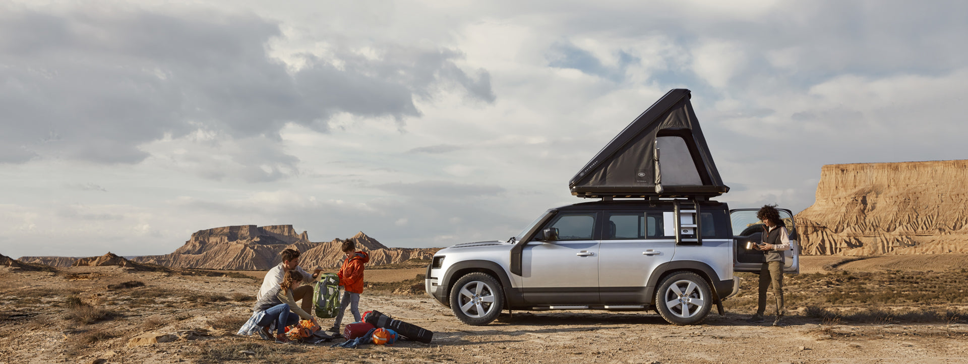 Land Rover Defender con tenda da tetto Autohome aperta in un paesaggio desertico