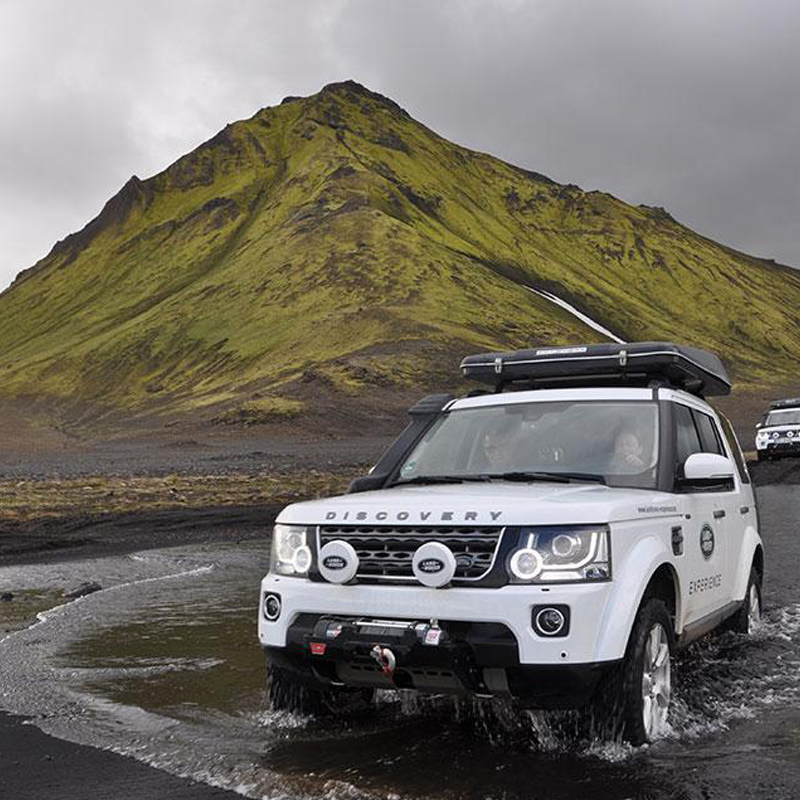 Land Rover Discovery con tenda da tetto Autohome che attraversa un guado
