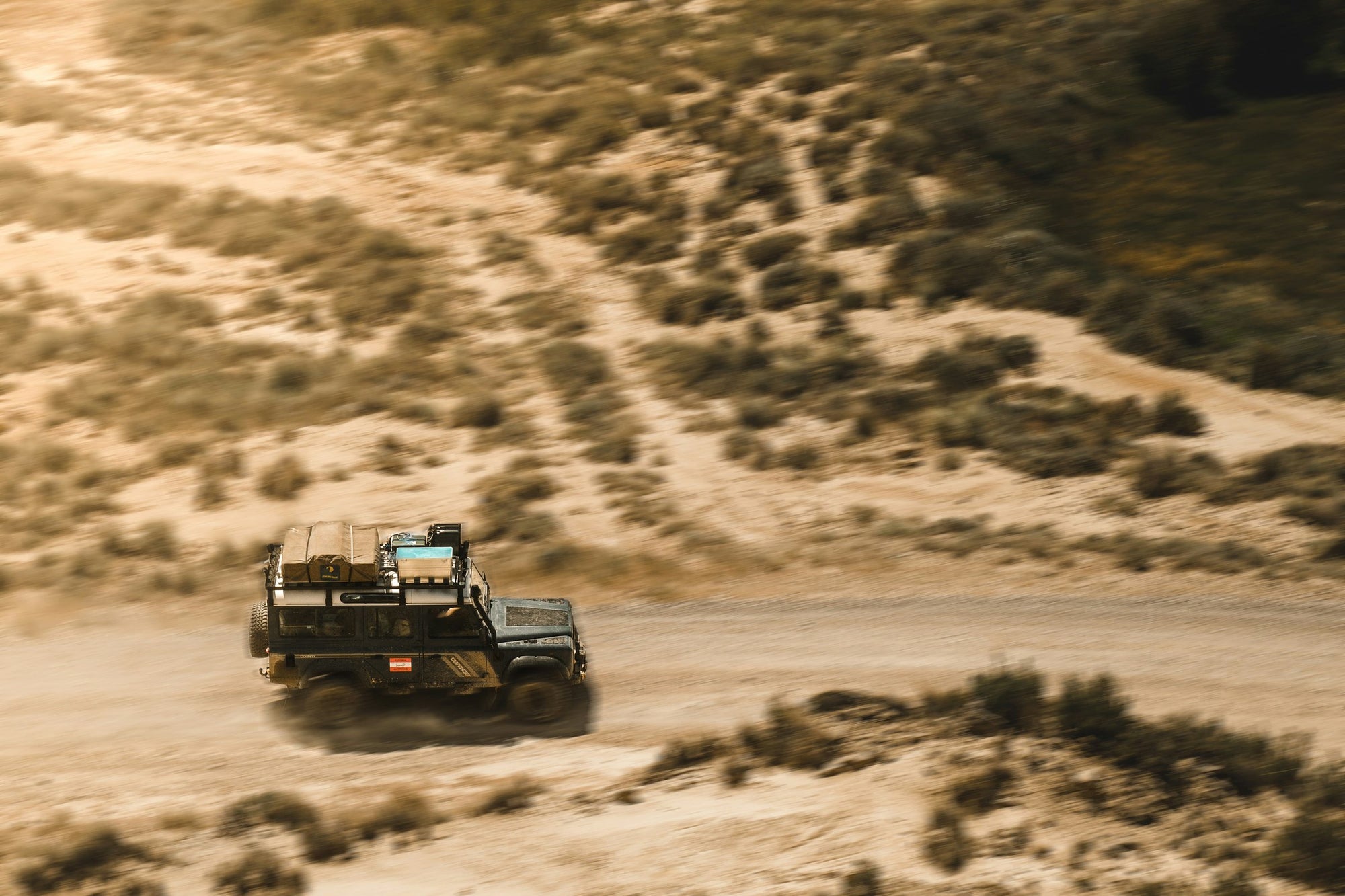 Land Rover Defender attrezzato per overlanding su pista polverosa