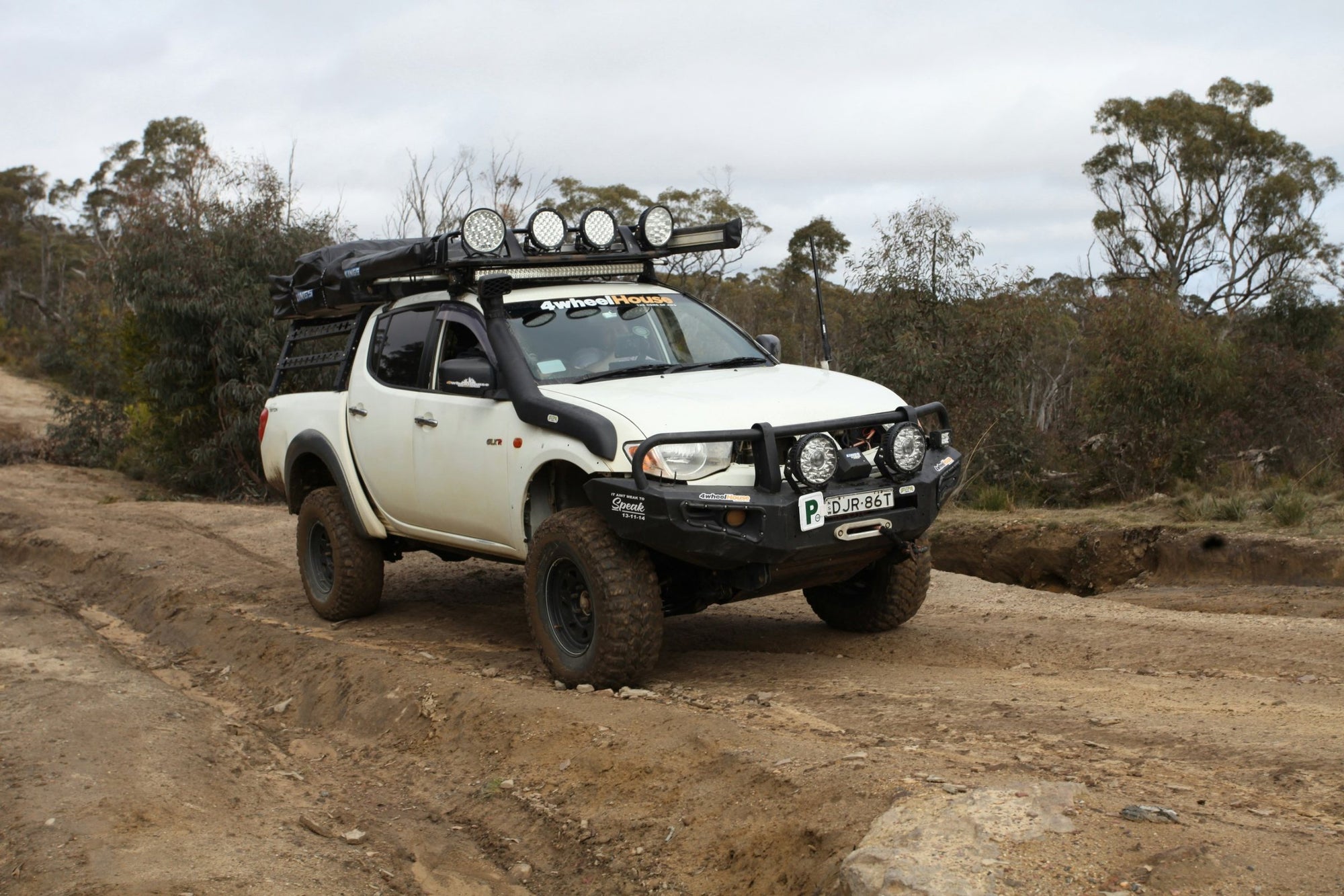 Pick-up 4x4 con bull bar, snorkel e fari LED sul tetto su pista sterrata