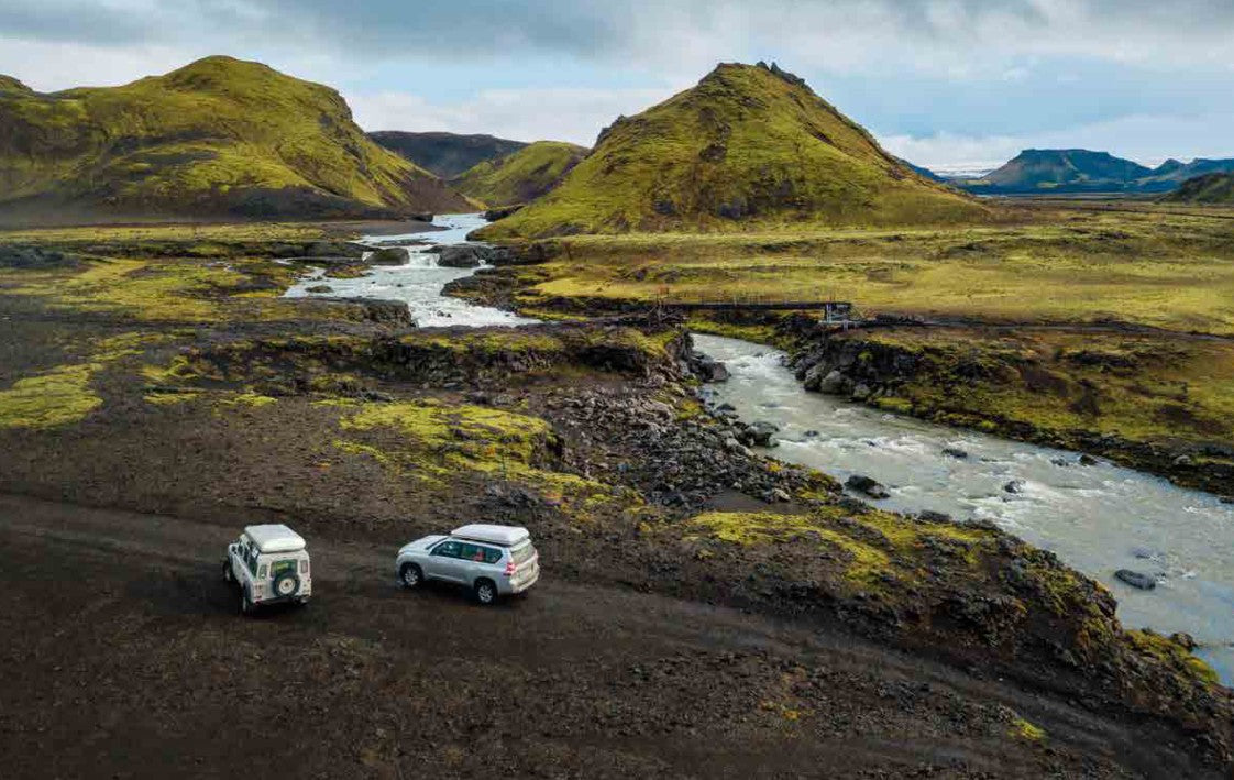 Due fuoristrada con tende da tetto Autohome chiuse su una pista sterrata lungo un fiume