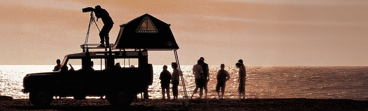 Fuoristrada con tenda da tetto Autohome Maggiolina aperta al tramonto sul mare