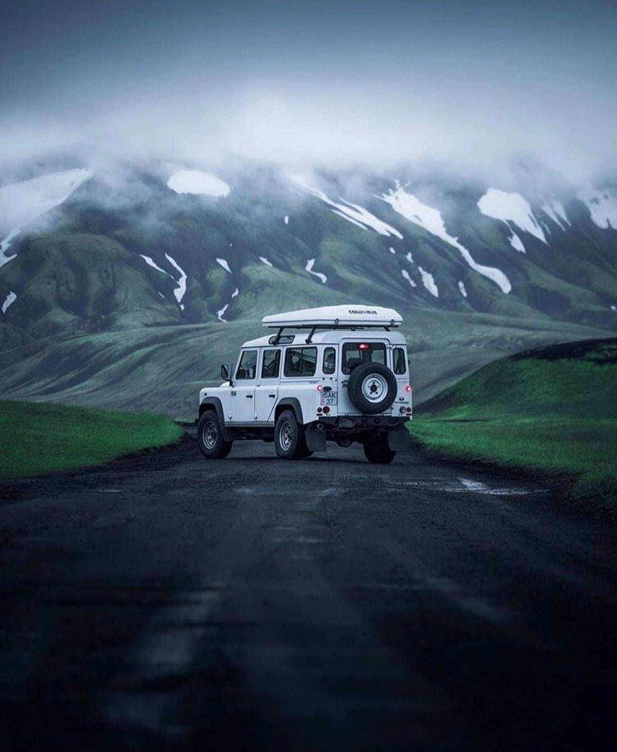 Land Rover Defender con tenda da tetto Autohome Columbus chiusa su una strada di montagna