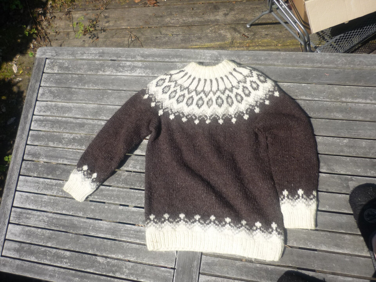 Maglione islandese tradizionale in lana lopapeysa steso su un tavolo di legno