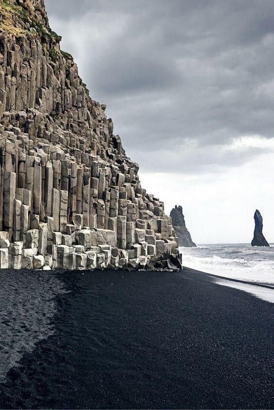 Colonne di basalto sulla spiaggia nera di Reynisfjara con i faraglioni