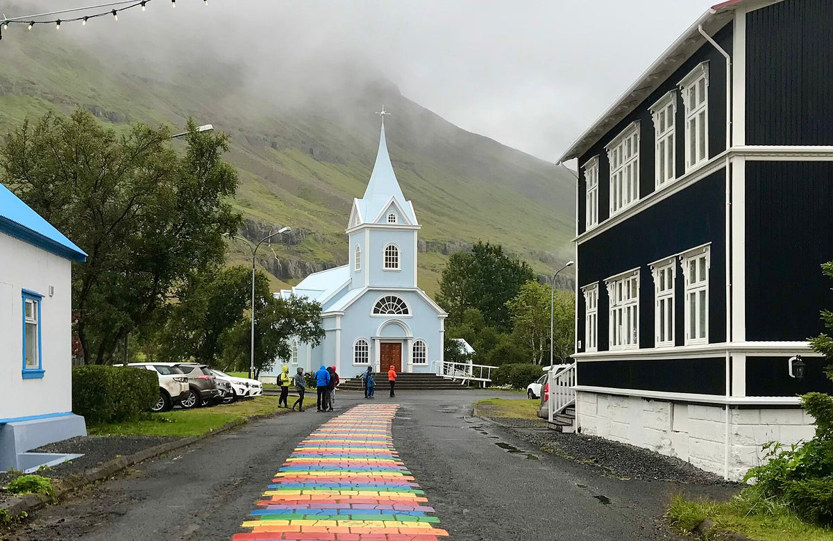 La chiesa blu di Seyðisfjörður con la Rainbow Street dipinta davanti