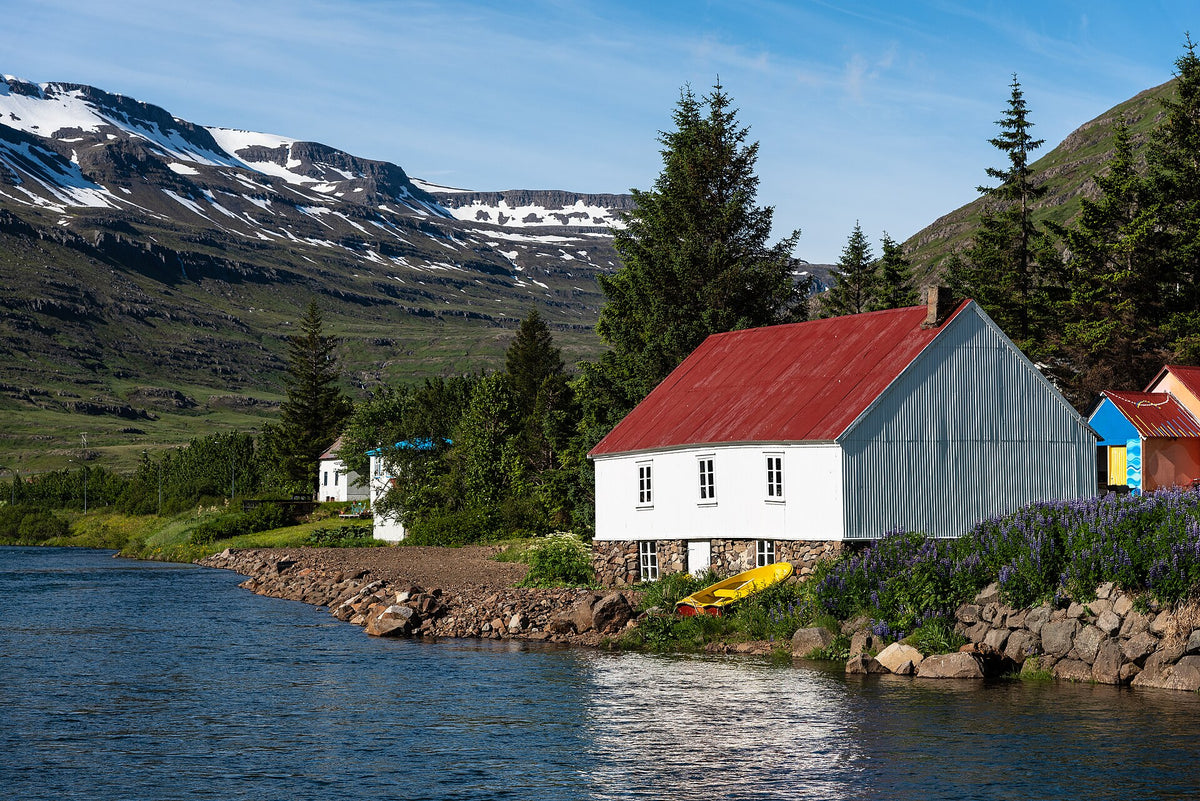 Casa rossa sul fiume Fjarðará a Seyðisfjörður con montagne innevate sullo sfondo