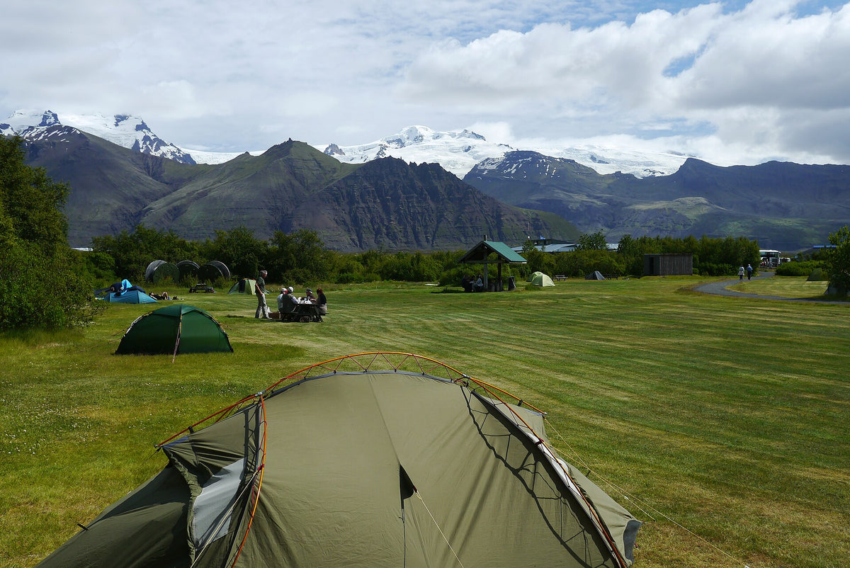 Campeggio di Skaftafell con tende sul prato e montagne del Vatnajökull sullo sfondo