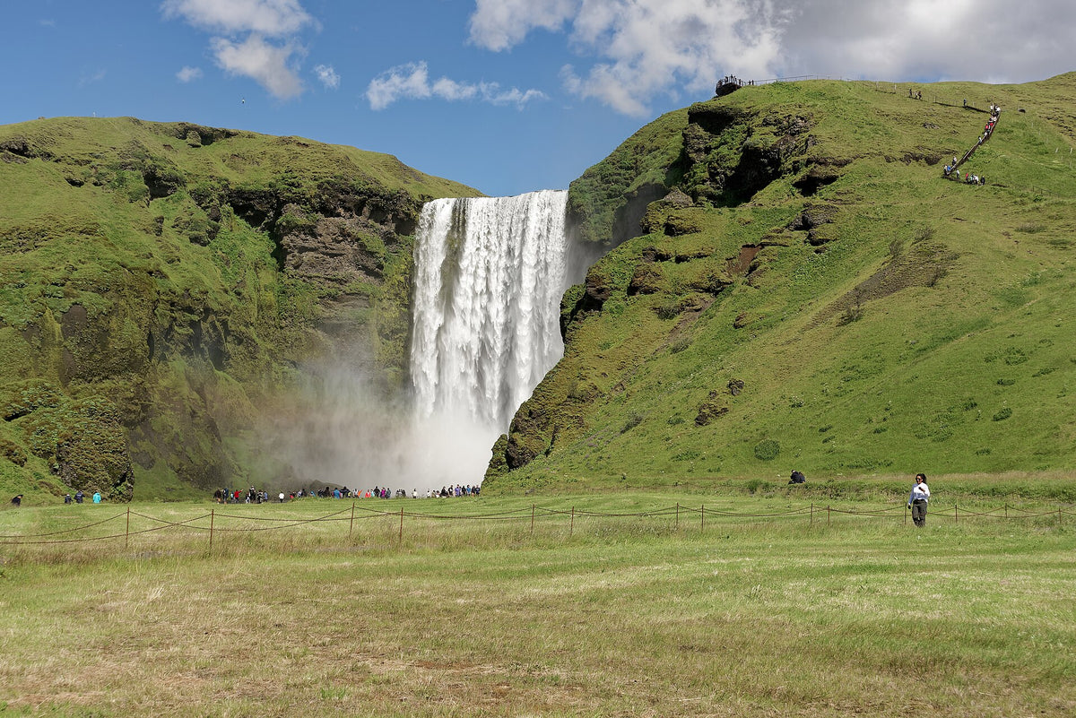La cascata di Skógafoss vista dal prato con visitatori alla base