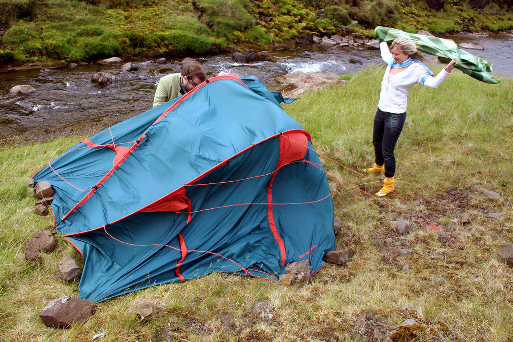 Campeggiatori che lottano con una tenda piegata dal vento forte in Islanda
