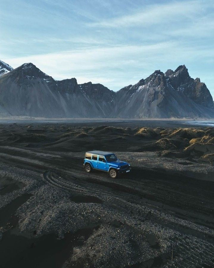 Jeep Wrangler blu sulla sabbia nera di Stokksnes sotto il Vestrahorn