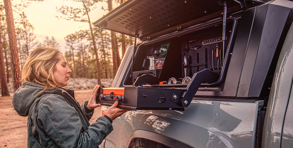 Donna che prepara il caffè alla cucina da campo laterale di un hard top su pick-up